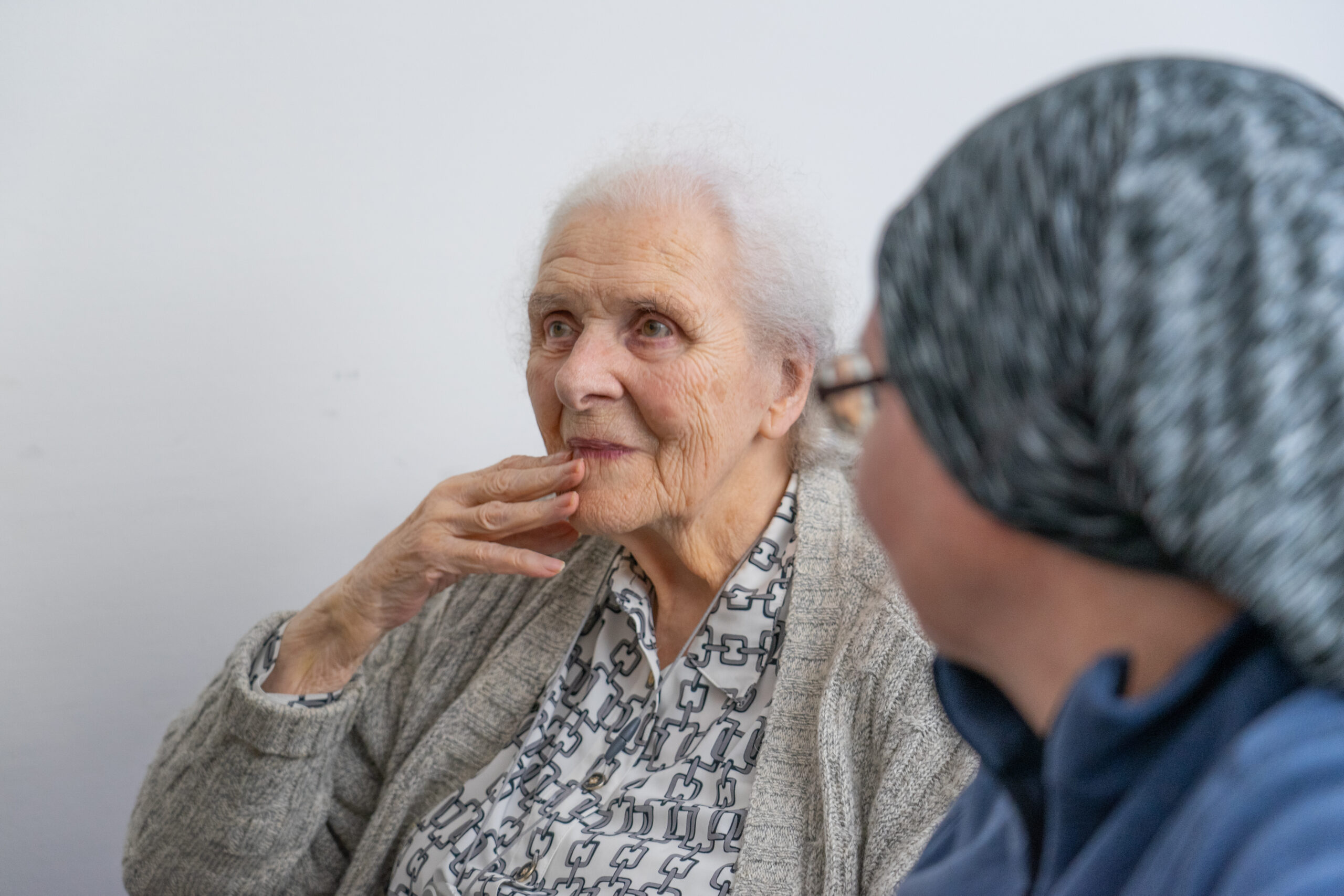 Bliska osoba siedzi obok pacjentki i rozmawia z nią
